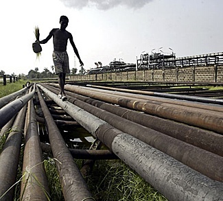 civilian walking along pipes in the Niger Delta