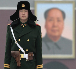 A paramilitary policeman stands guard in front of a portrait of former Communist Party chairman Mao Zedong at Tiananmen Square in Beijing