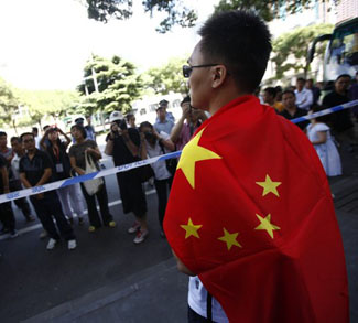 A Chinese man wraps in a Chinese flag during an anti-Japan protest over disputed islands called Diaoyu in China and Senkaku in Japan, near the Japanese consulate in Shanghai
