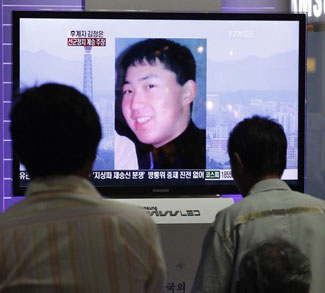South Koreans watch a television news report showing the person believed to be Kim Jong-un, the youngest son of North Korean leader Kim Jong-il, at the Seoul railway station