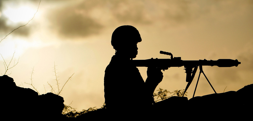 SOMALIA, Mogadishu: In a handout photograph dated 30 April and released by the African Union-United Nations Information Support Team 01 Mayl, a Ugandan soldier of 341 Battalion serving with the African Union Mission in Somalia (AMISOM) holds a rocket-propelled grenade at sunrise on the frontline near the main road on the northern edge of Maslah Town, the northern city limit of the Somali capital Mogadishu. AMISOM troops, now numbering 11,400 out of a mandated total of 17,731, supporting forces of the Transitional Federal Government have driven the Al-Qaeda-linked extremist group Al Shabaab out of the Somali capital where life is returning to the seaside city after years of conflict and Somalis are enjoying the longest period of relative peace not experienced since 1991. AU-UN IST PHOTO /STUART PRICE. AMISOM2, cc Flickr AMISOM Public Information, modified, https://creativecommons.org/publicdomain/zero/1.0/