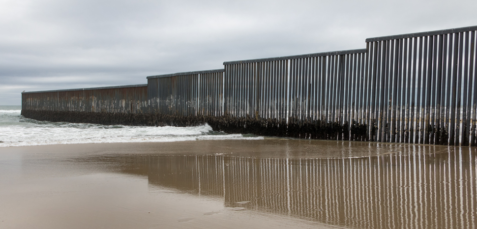 TijuanaWall, cc © Tomas Castelazo, www.tomascastelazo.com / Wikimedia Commons, modified, https://en.wikipedia.org/wiki/Mexico%E2%80%93United_States_barrier#/media/File:Mexico-US_border_at_Tijuana.jpg