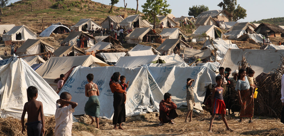 Rohingya camp, cc DFID - UK Department for International Development - Emergency food, drinking water and shelter to help people displaced in Rakhine State, western Burma., modified, https://en.wikipedia.org/wiki/Rohingya_people#/media/File:Emergency_food,_drinking_water_and_shelter_to_help_people_displaced_in_Rakhine_State,_western_Burma._(8288488088).jpg