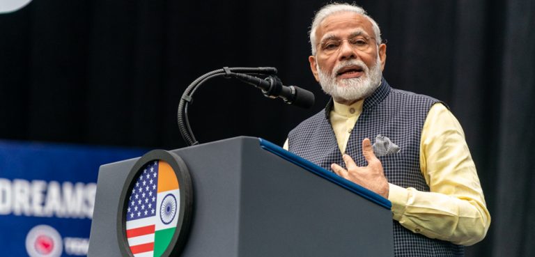 Prime Minister Modi in Texas, USA. CC Flickr White House, public domain, modified, Prime Minister Narendra Modi of India addresses his remarks on stage Sunday, Sept. 22, 2019, at a rally in honor of Prime Minister Modi at NRG Stadium in Houston, Texas. (Official White House Photo by Shealah Craighead)